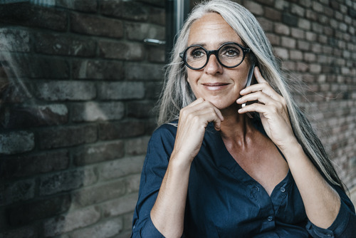A businesswoman smiling and holding a phone to her ear