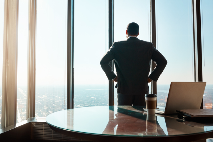 executive looking out of window in contemplation