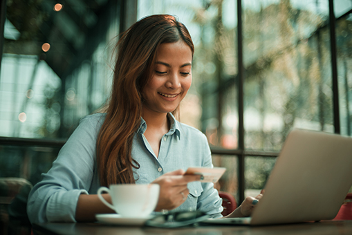 woman sitting next to laptop and coffee