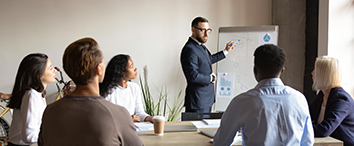 Picture of businessman presenting on the board to group of employees