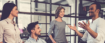 Picture of four pelople in office having a casual conversation