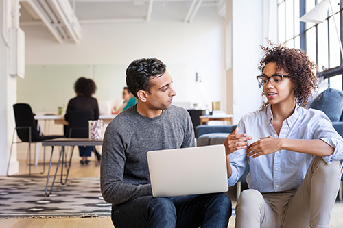 business-people-talking-while-using-laptop