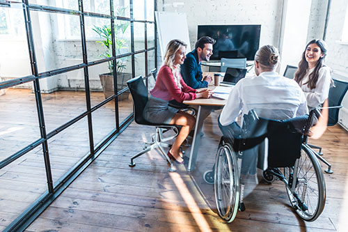 young-disabled-businessman-wheelchair-working-colleagues