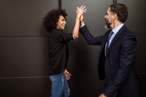 Two businesspeople high-fiving each other