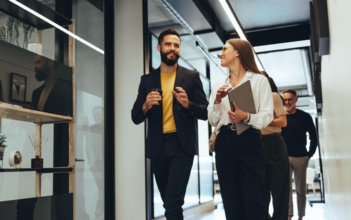 Employees engaging in a hallway discussion at work