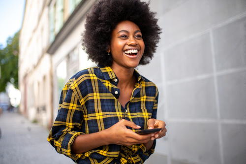 businesswoman smiling, holding a mobile phone