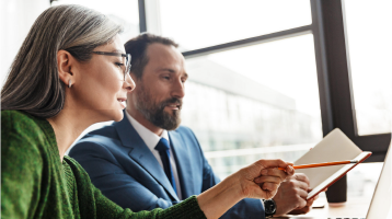 Two businesspeople looking at a report