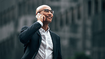 A businessman smiling, holding a phone to his ear