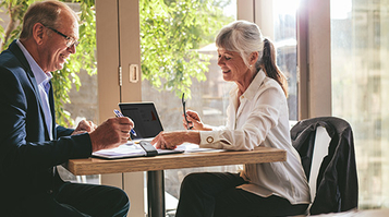 Business partners signing a contract at a coffee shop