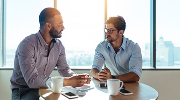 Business partners discussing business plans sitting at a table in office